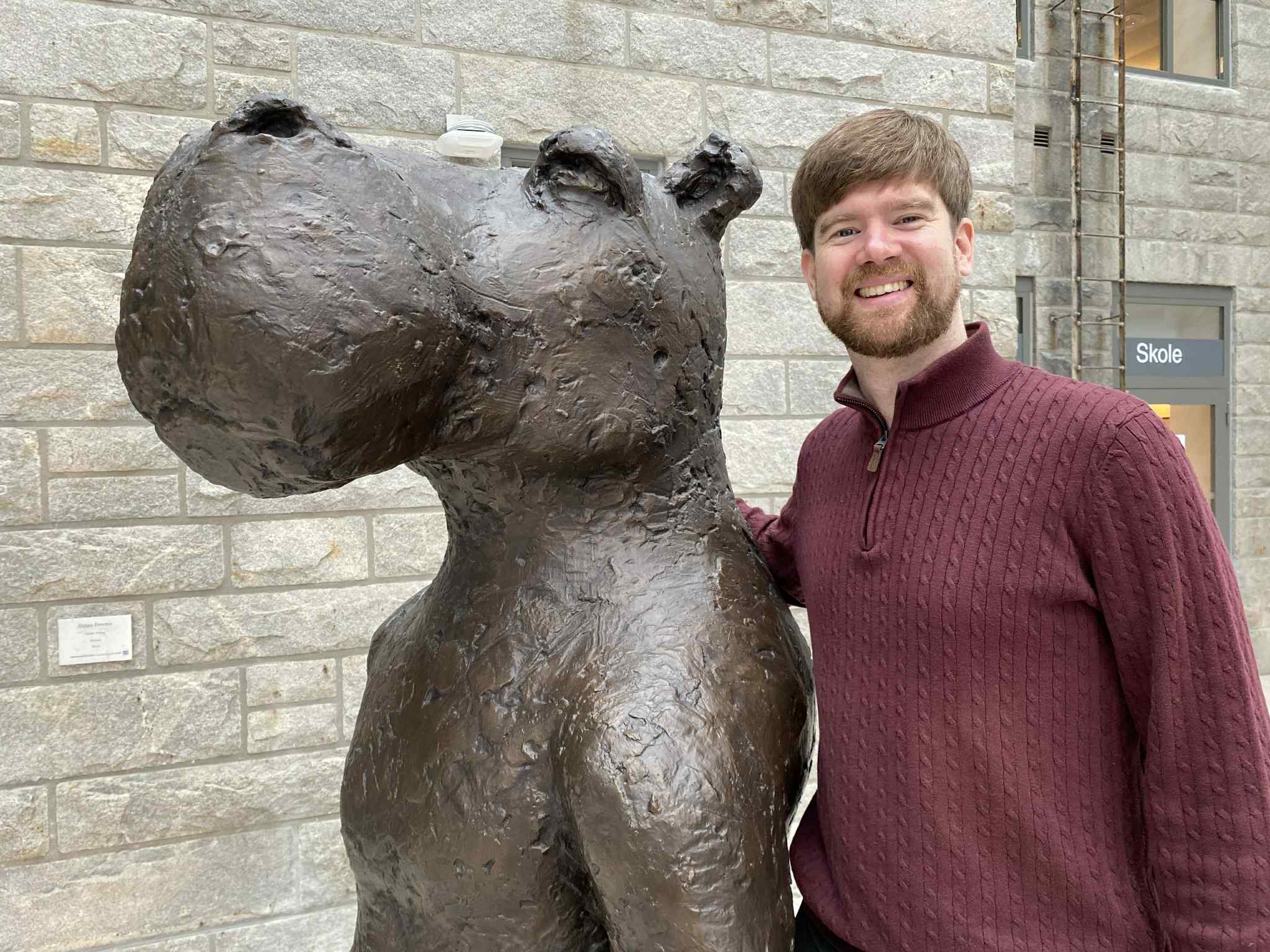 En mann som står ved siden av en statue