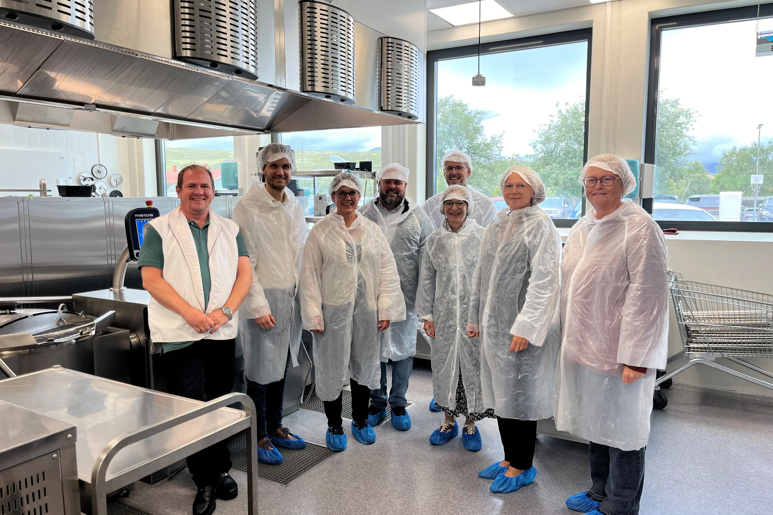 En gruppe mennesker i hvite laboratoriefrakker som står i et rom