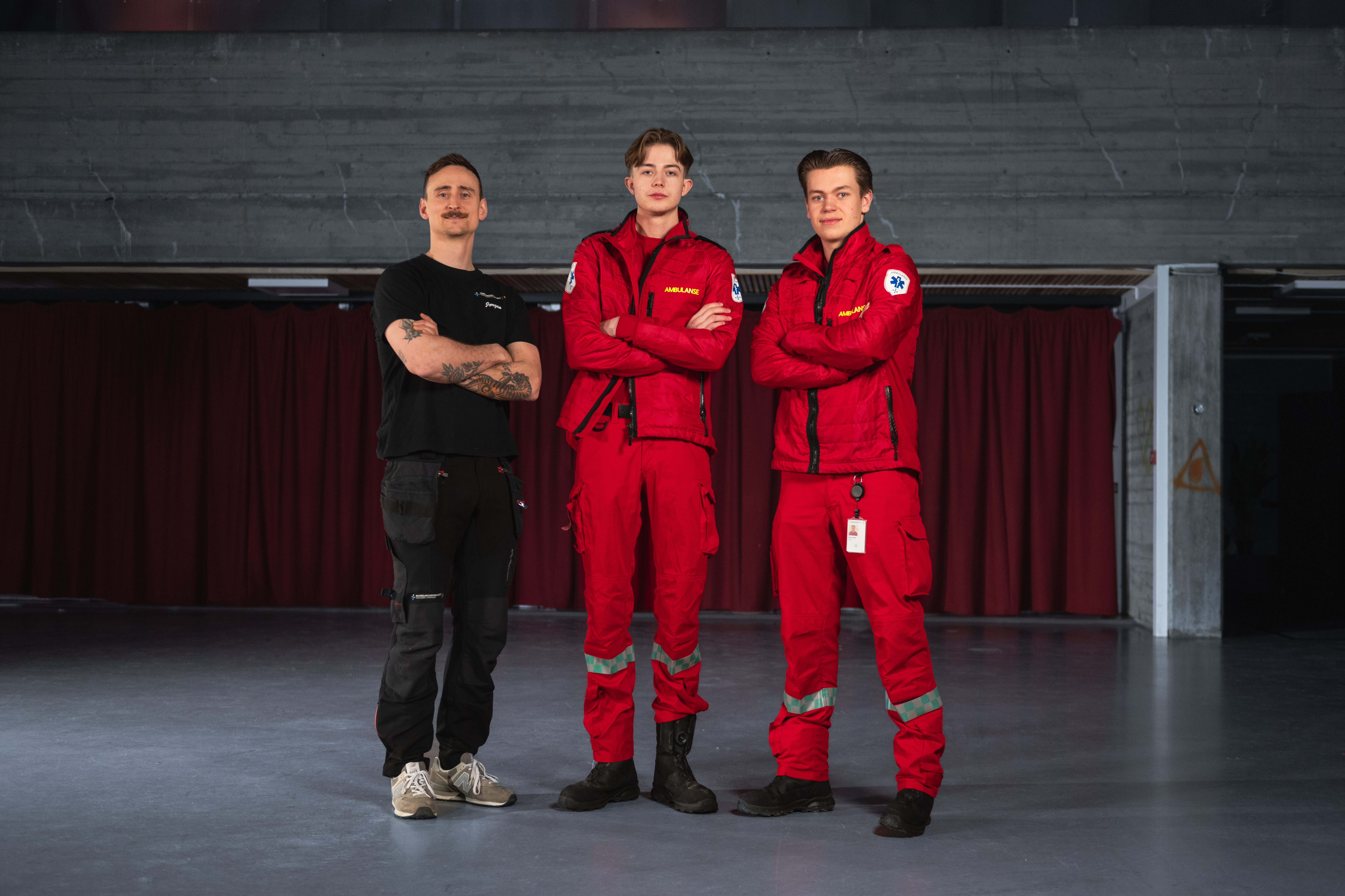 Tre personer som står oppstilt og ser mot kamera