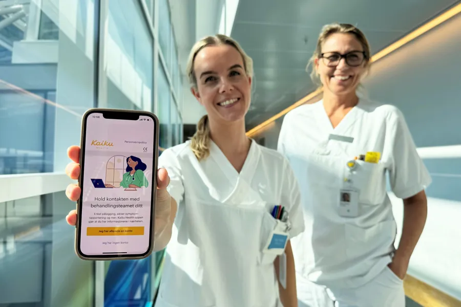 Et par kvinner i hvite frakker som holder en telefon