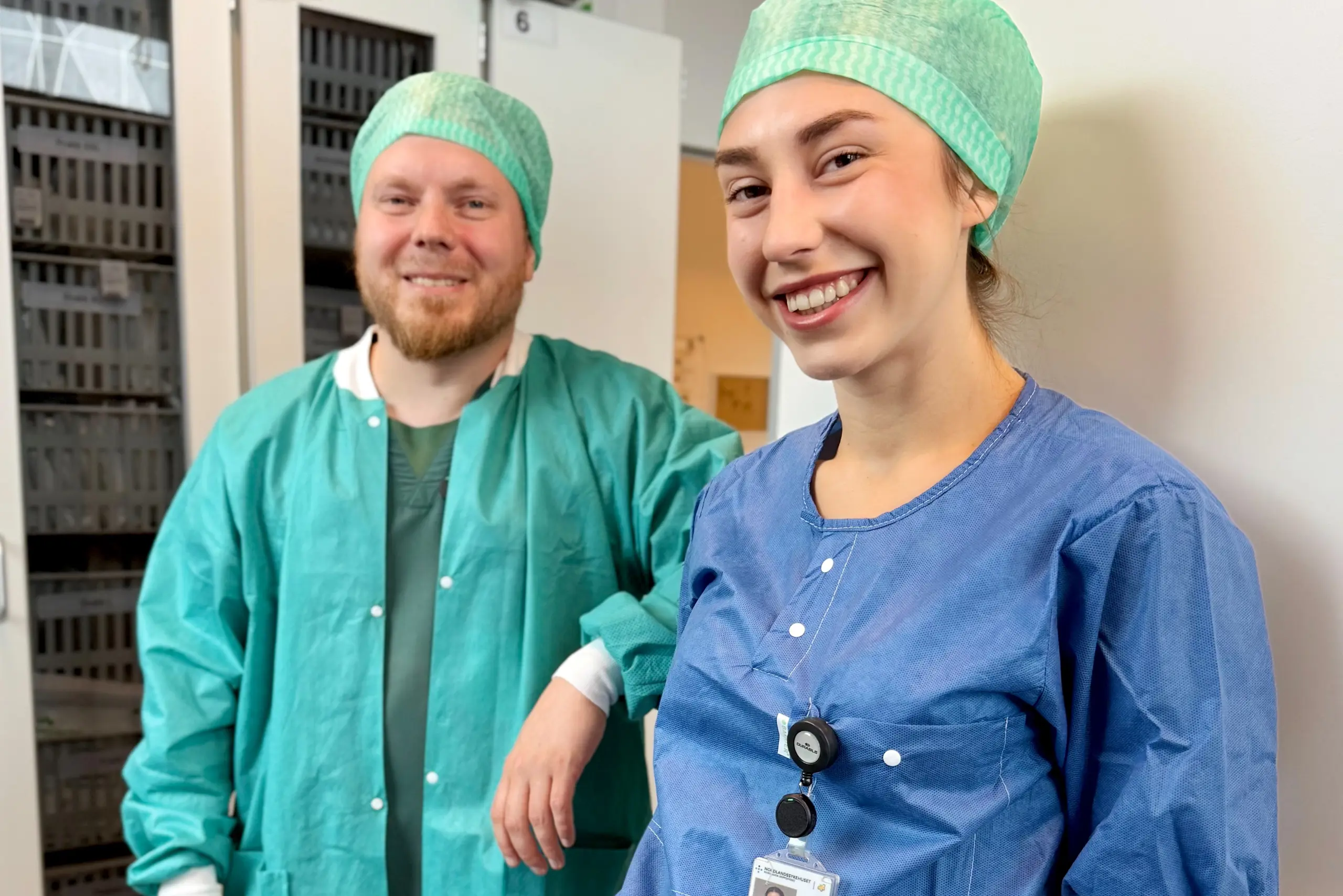 En mann og en kvinne med grønne opersjonshatter som smiler