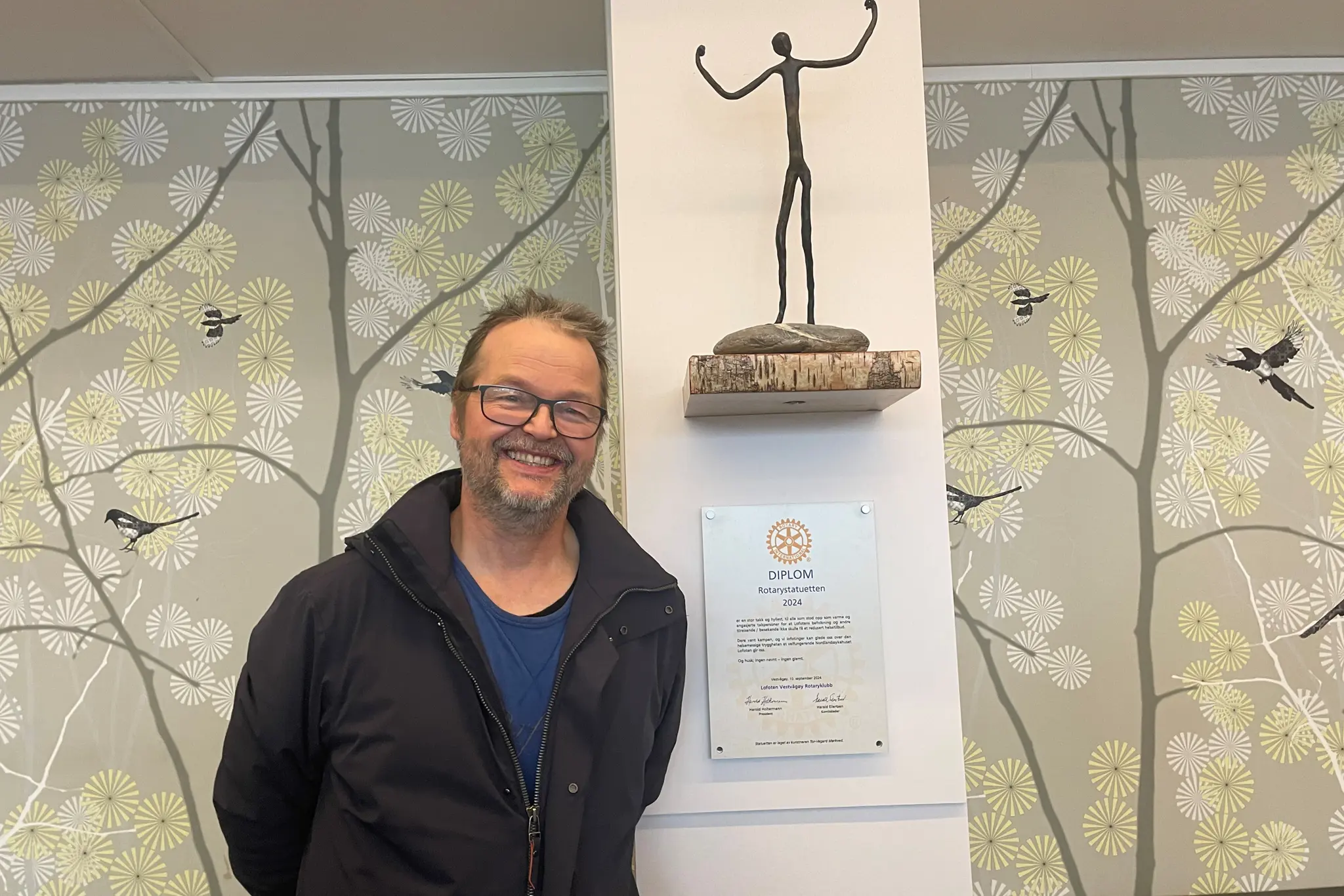 En mann som står foran en vegg med kunst på
