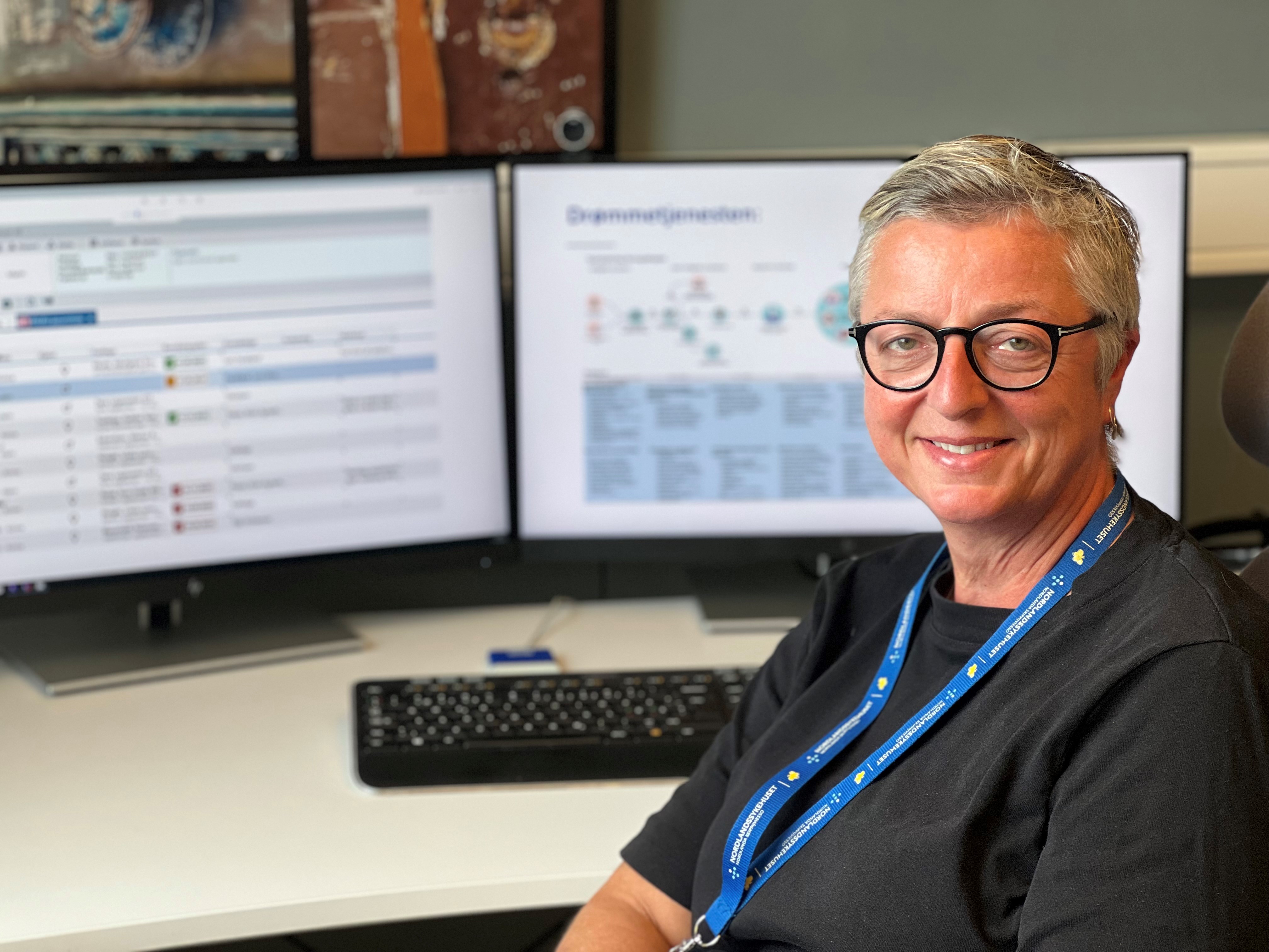 En mann som smiler foran en datamaskin