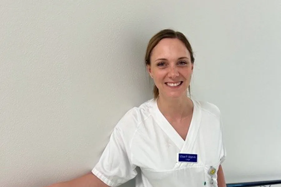 Dame i hvit bukse og skjorte