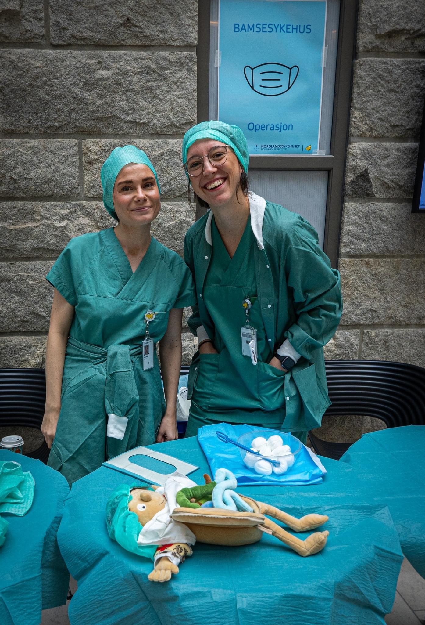 Et par kvinner i kirurgiske skrubb og skrubber som står ved siden av et bord med en hodeskalle