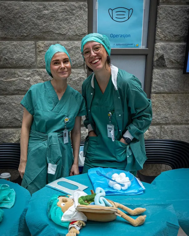 Et par kvinner i kirurgiske skrubb og skrubber som står ved siden av et bord med en hodeskalle