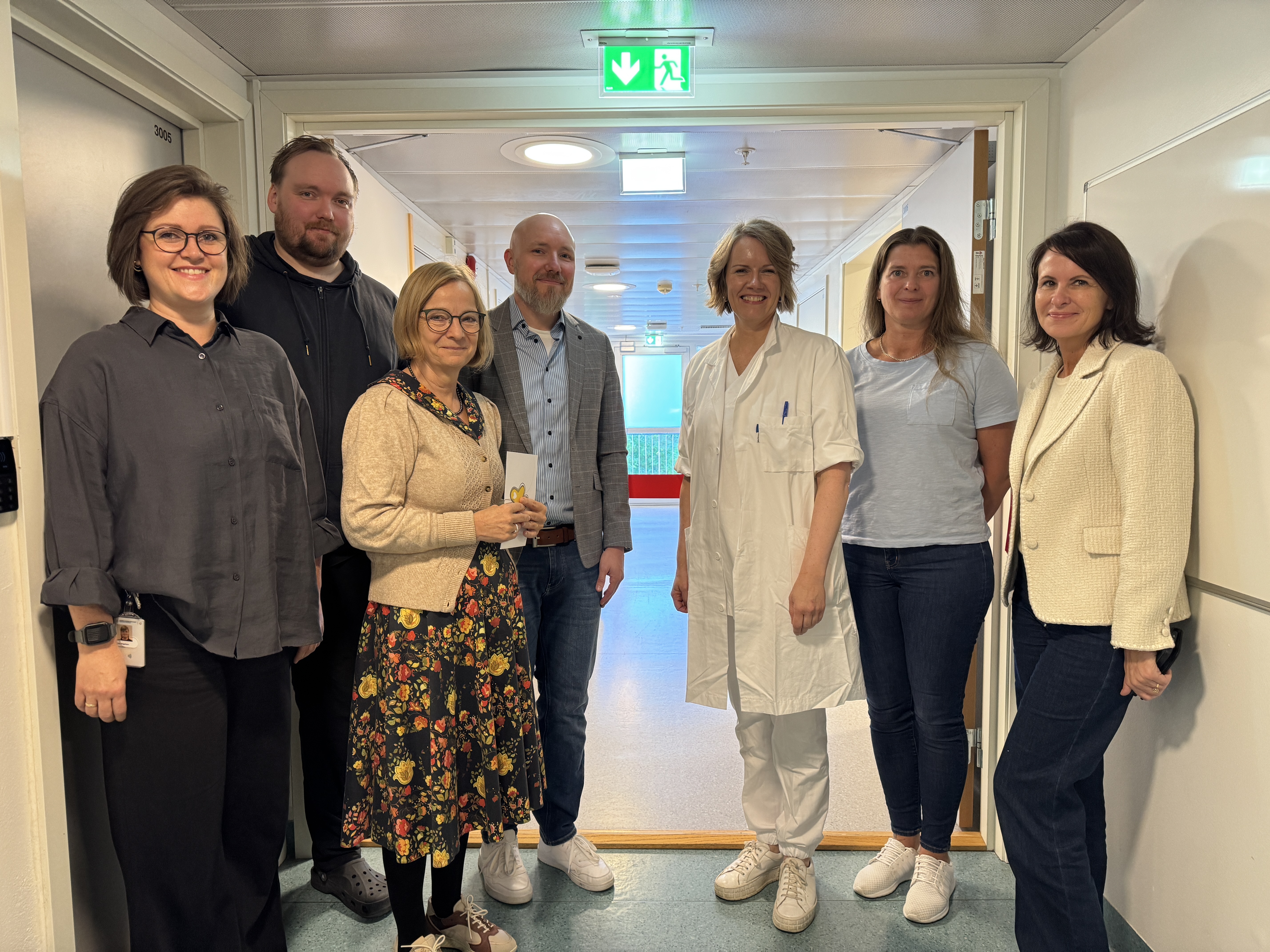 Gruppebilde av sju personer som smiler