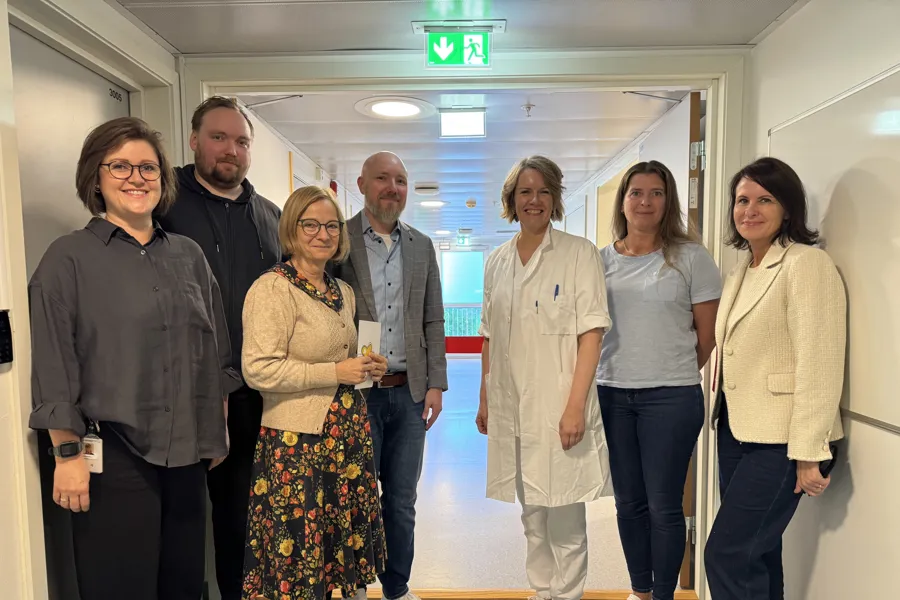 Gruppebilde av sju personer som smiler