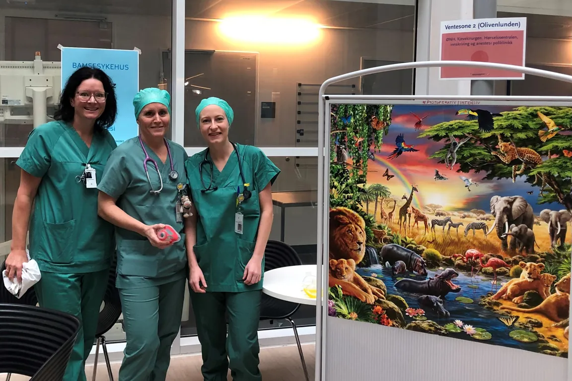 En gruppe kvinner som poserer for et bilde foran et stort akvarium