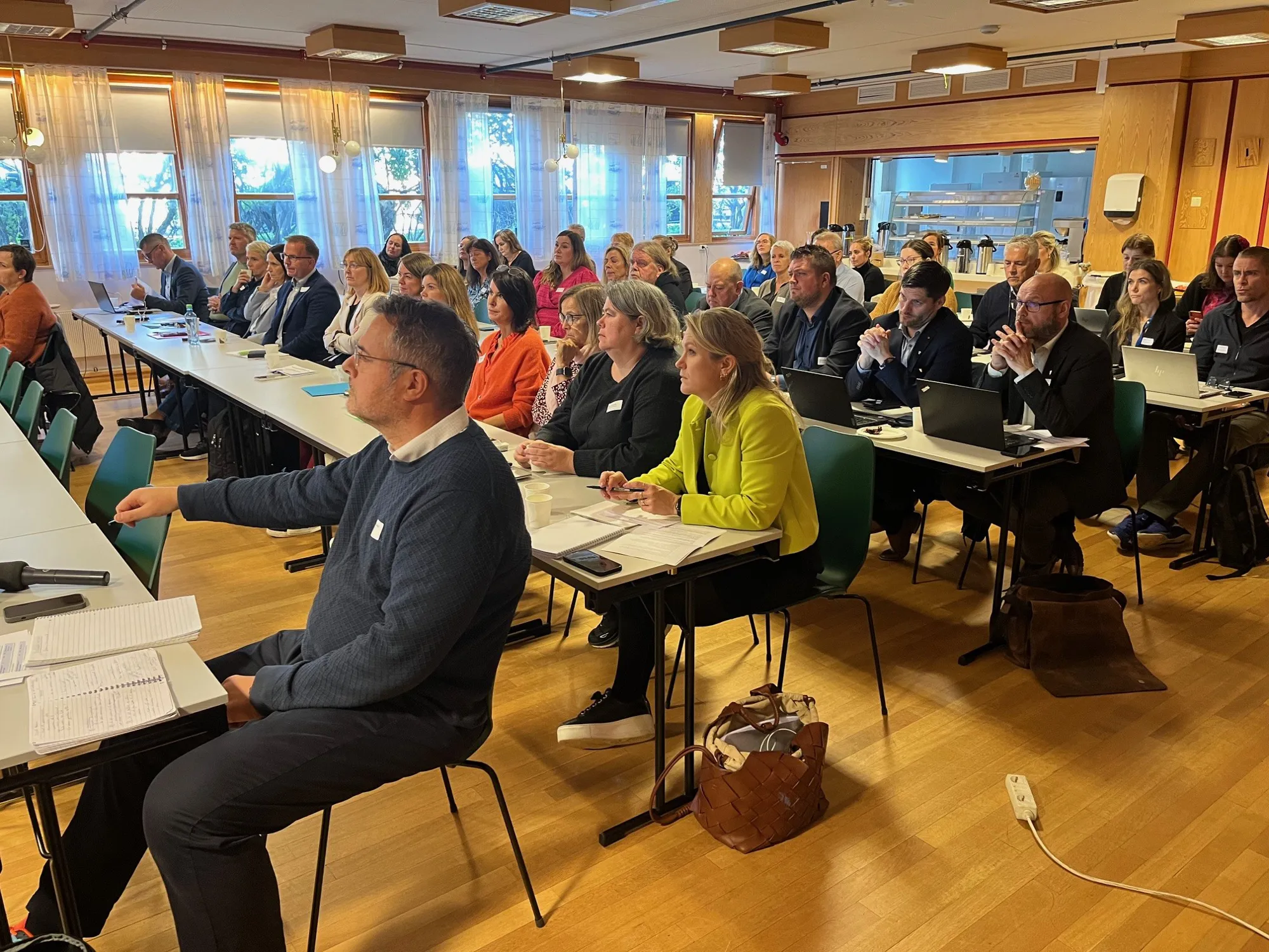 En gruppe mennesker som sitter ved bord