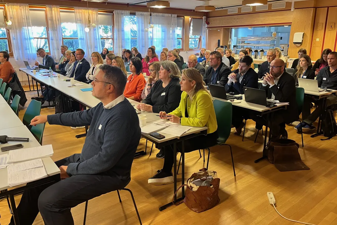 En gruppe mennesker som sitter ved bord