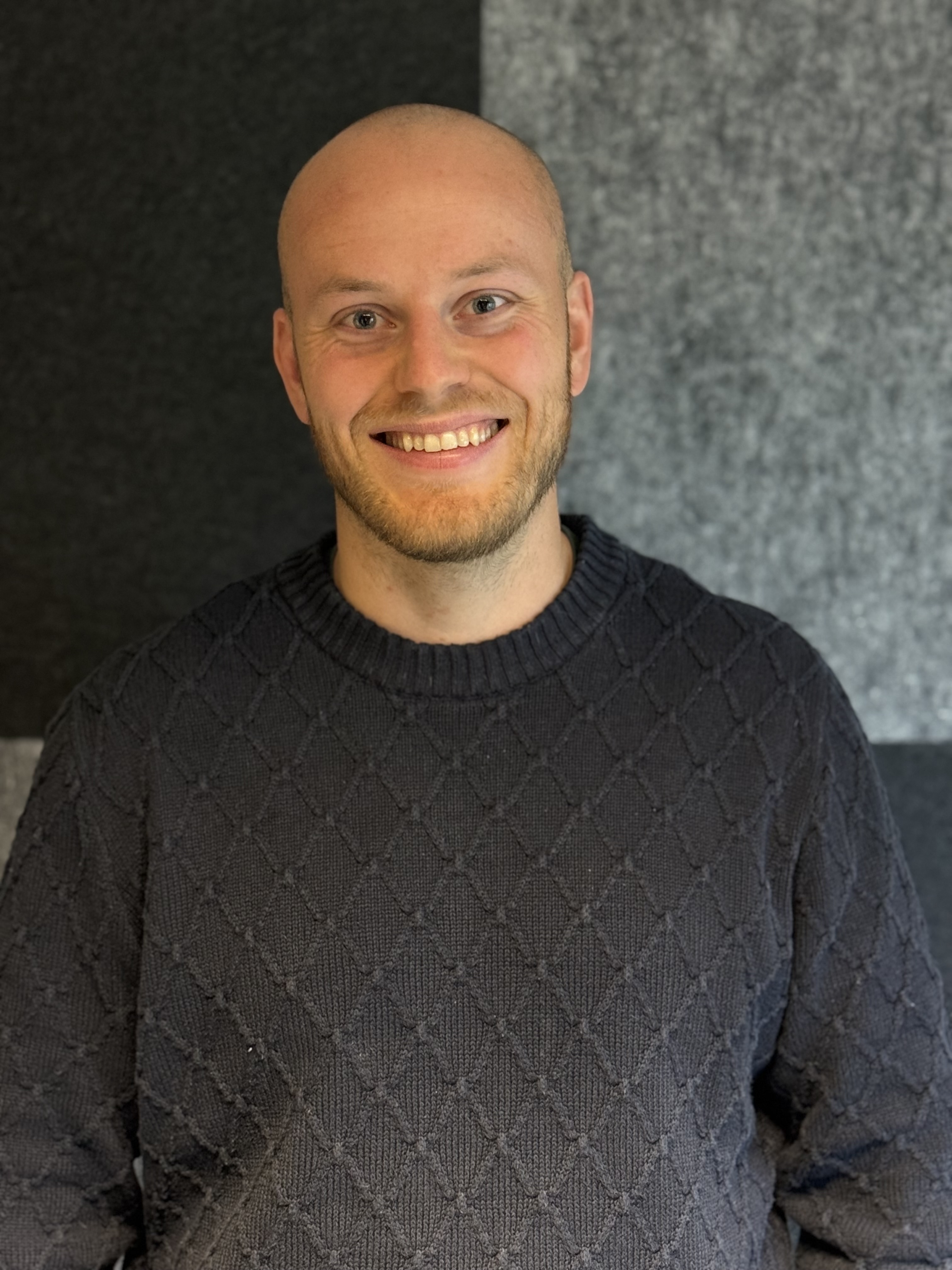 En mann som smiler til kameraet