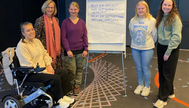 Gruppe på fem personer som står samlet
