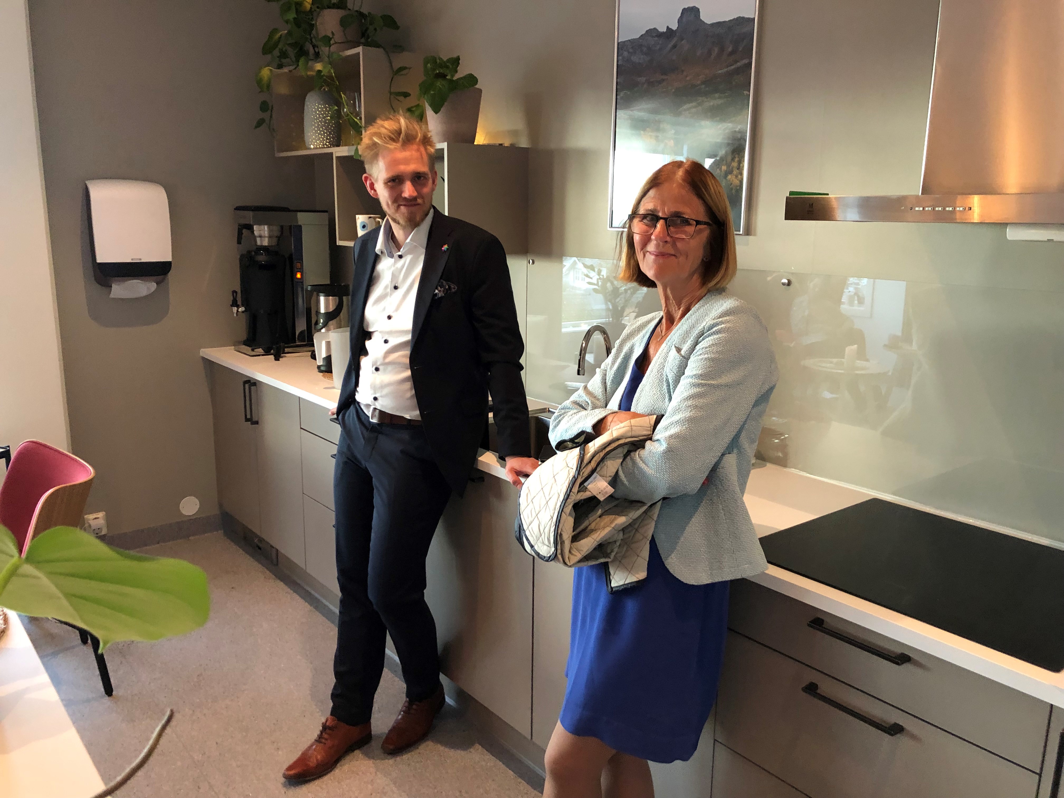 Mann og dame står på kjøkkenet og smiiler mot kamera