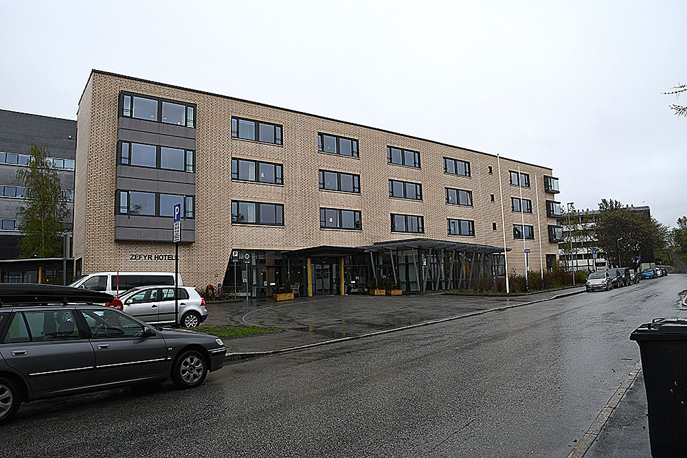 En bygning med biler parkert foran