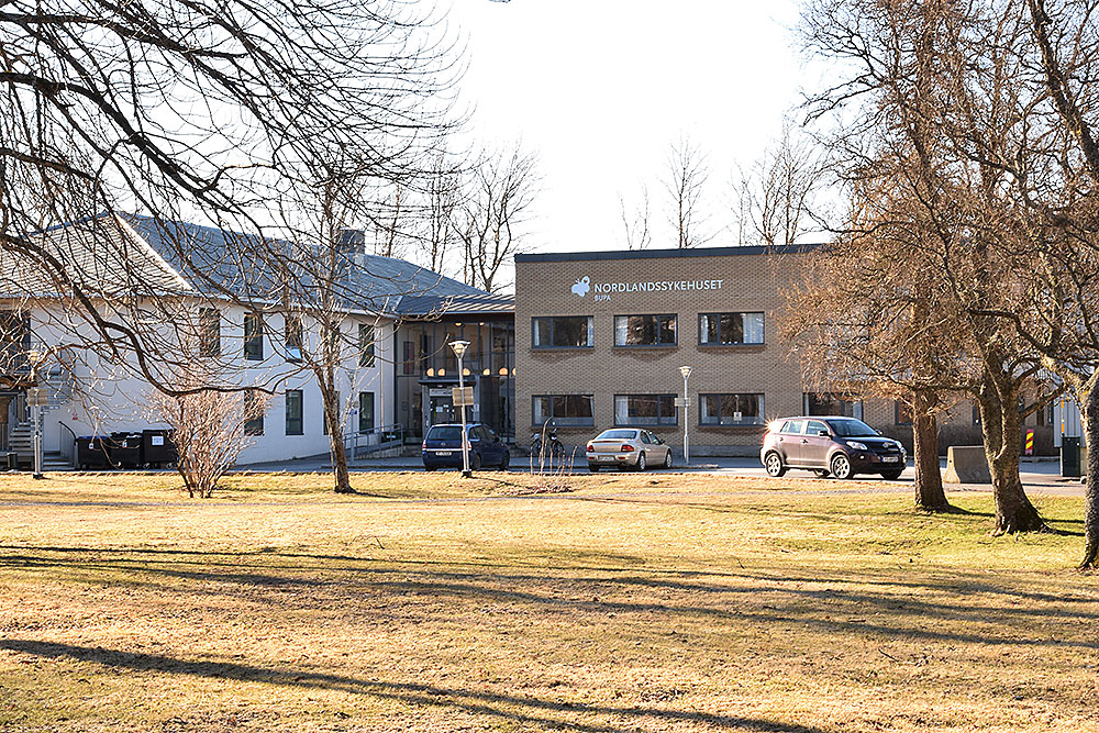 En bygning med biler parkert foran