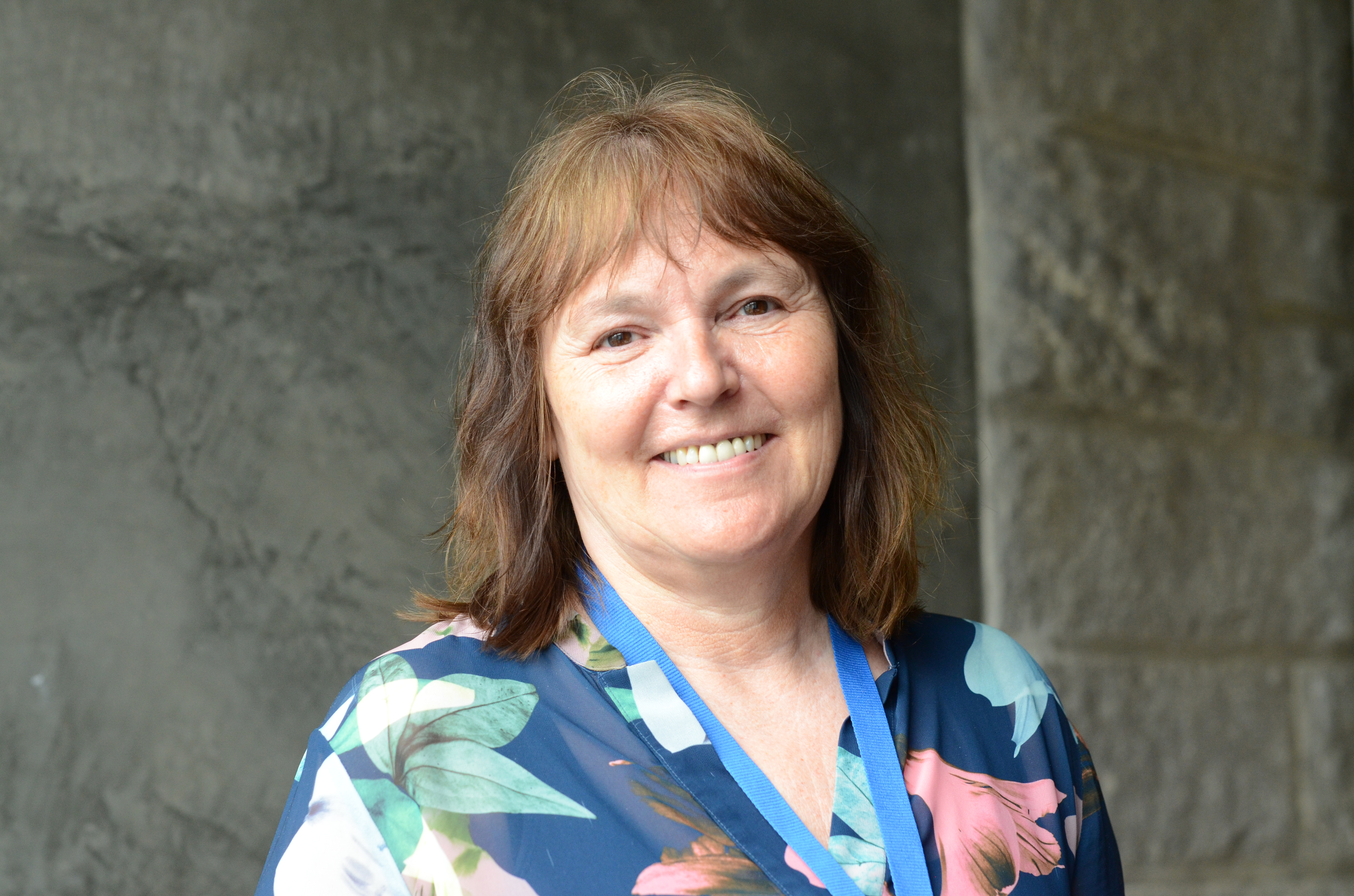 Dame i sort jakke foran rød vegg