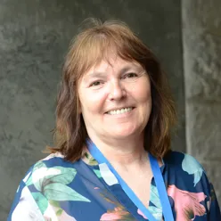 Dame i sort jakke foran rød vegg