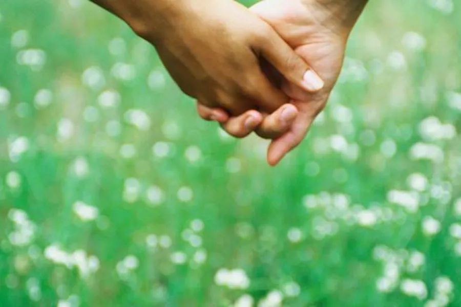 Et nærbilde av et par hender som holder hverandre