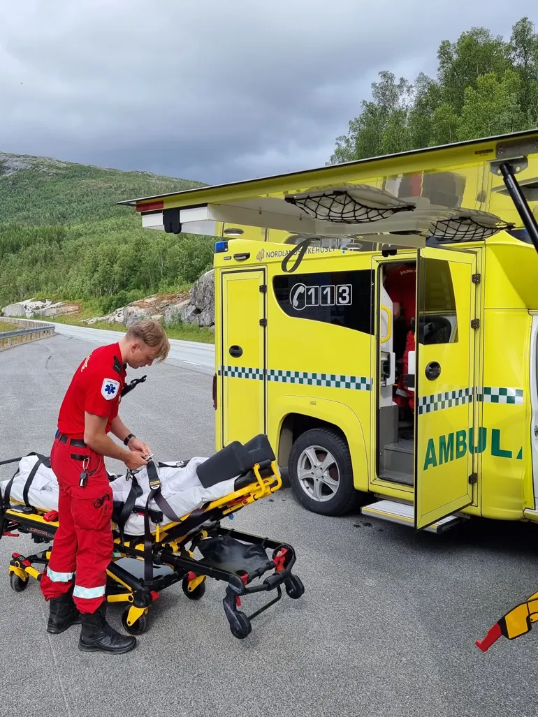 Mann med båre utenfor ambulanse