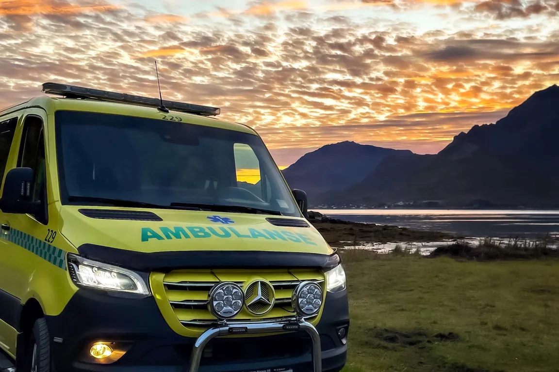 Ambulanse med fin natur bak seg