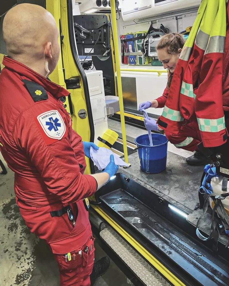 Ambulansearbeidere vasker ambulanse