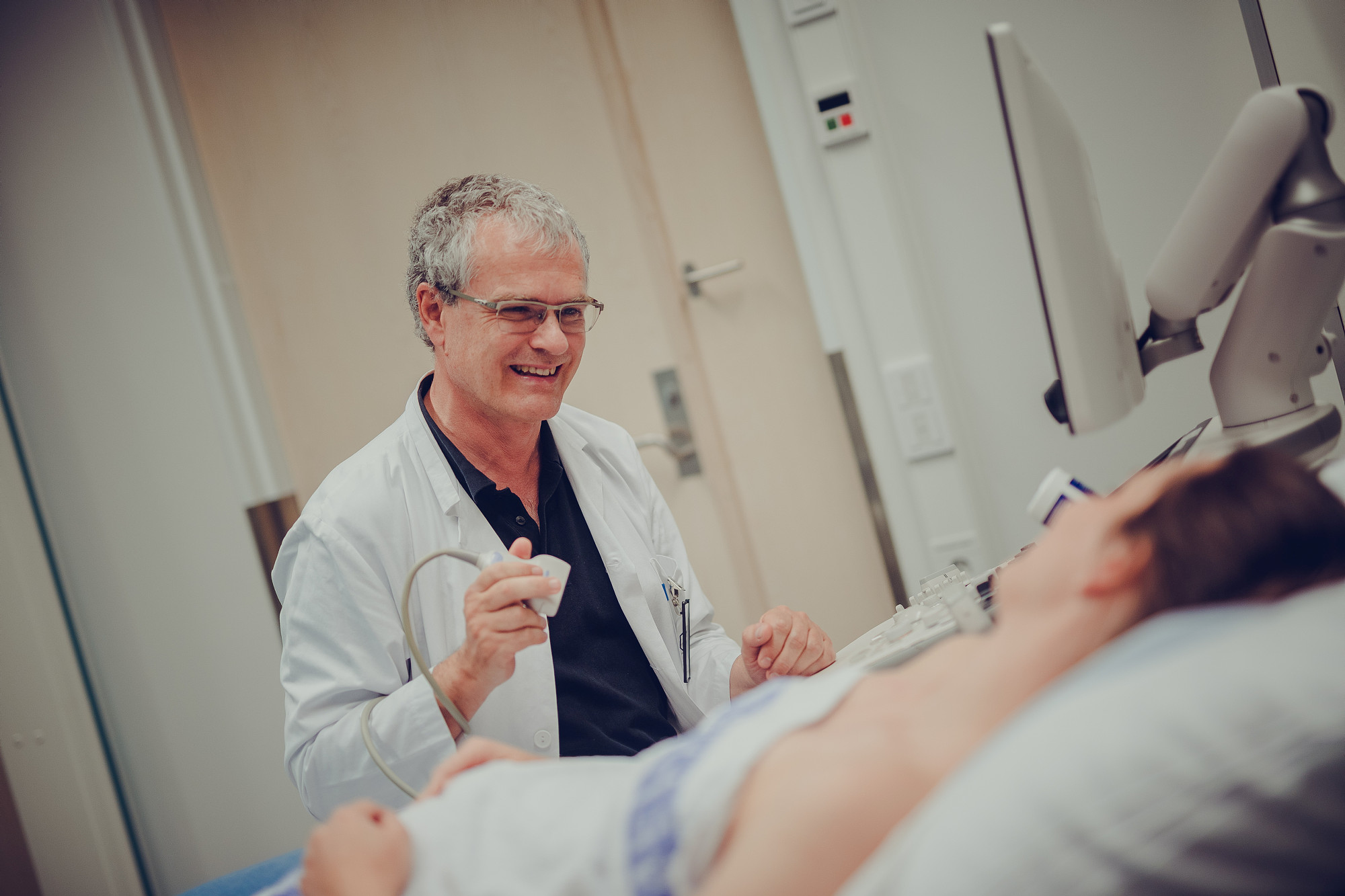 Mann som smiler og prater til pasient