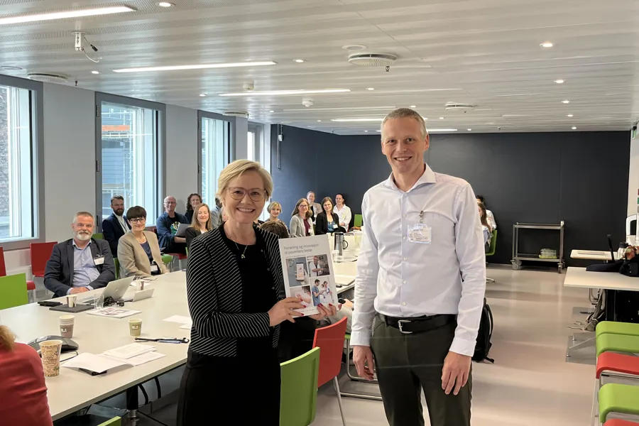 Helse- og omsorgsminister Ingvild Kjerkol fikk utdelt rapporten fra fagdirektør i Helse Vest, Bjørn Egil Vikse.