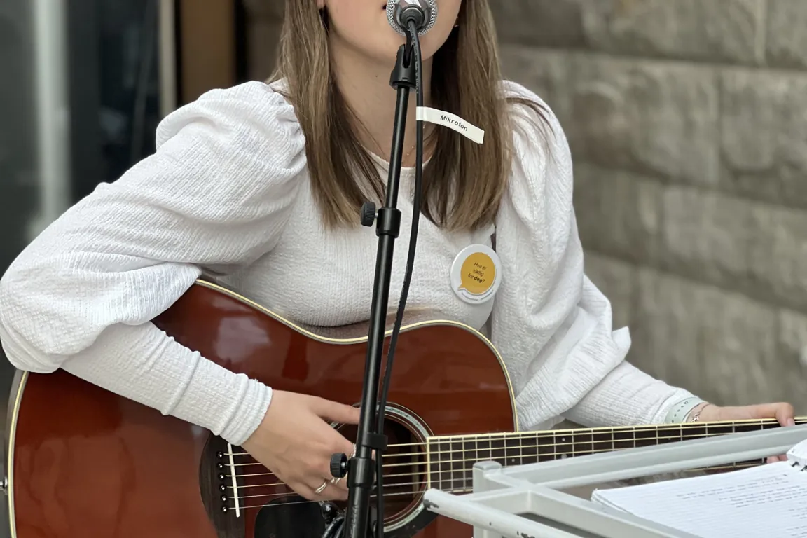 Dame som synger og spiller gitar