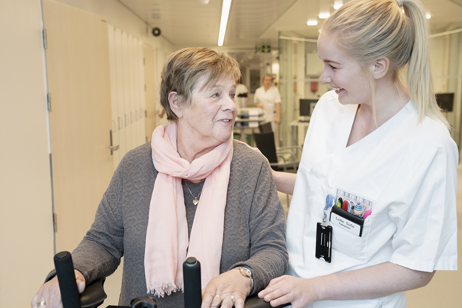 Sykepleier som smiler til eldre pasient