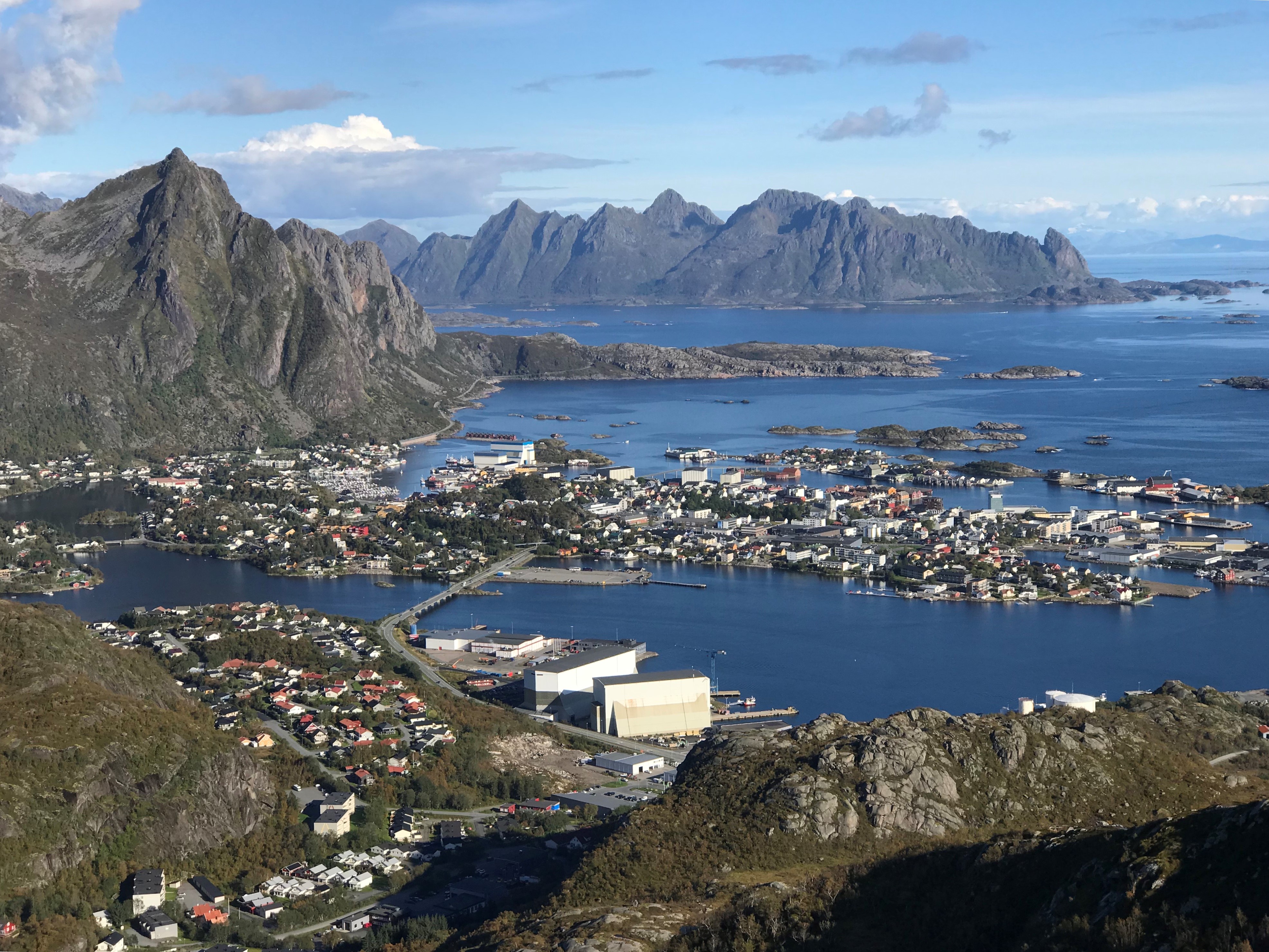 Lofoten next to a body of water with mountains in the background