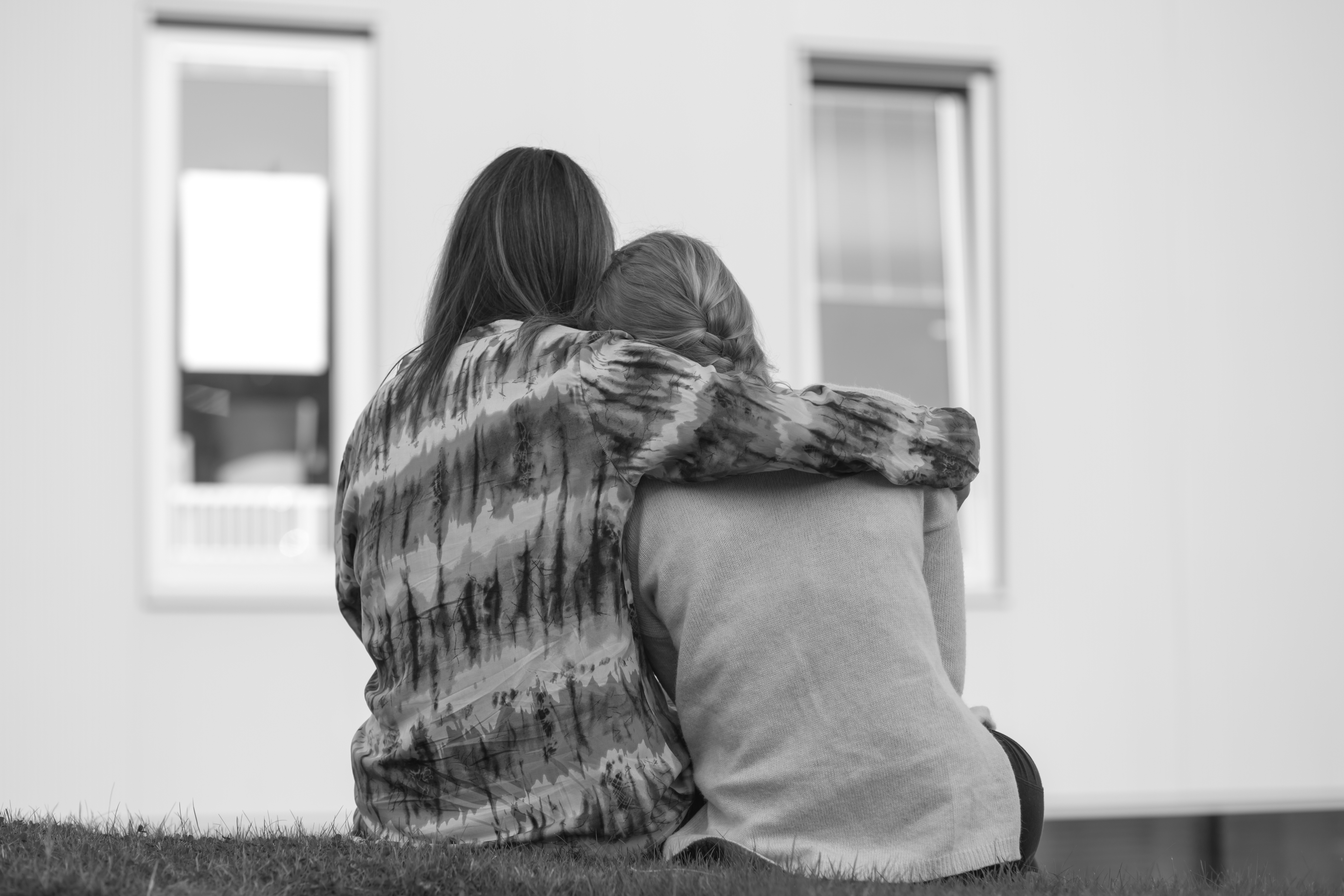 Voksen og ungdom sitter sammen ute