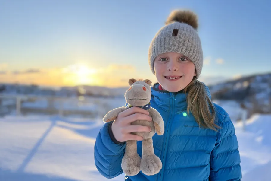 Jente som holder en bamse og smiler