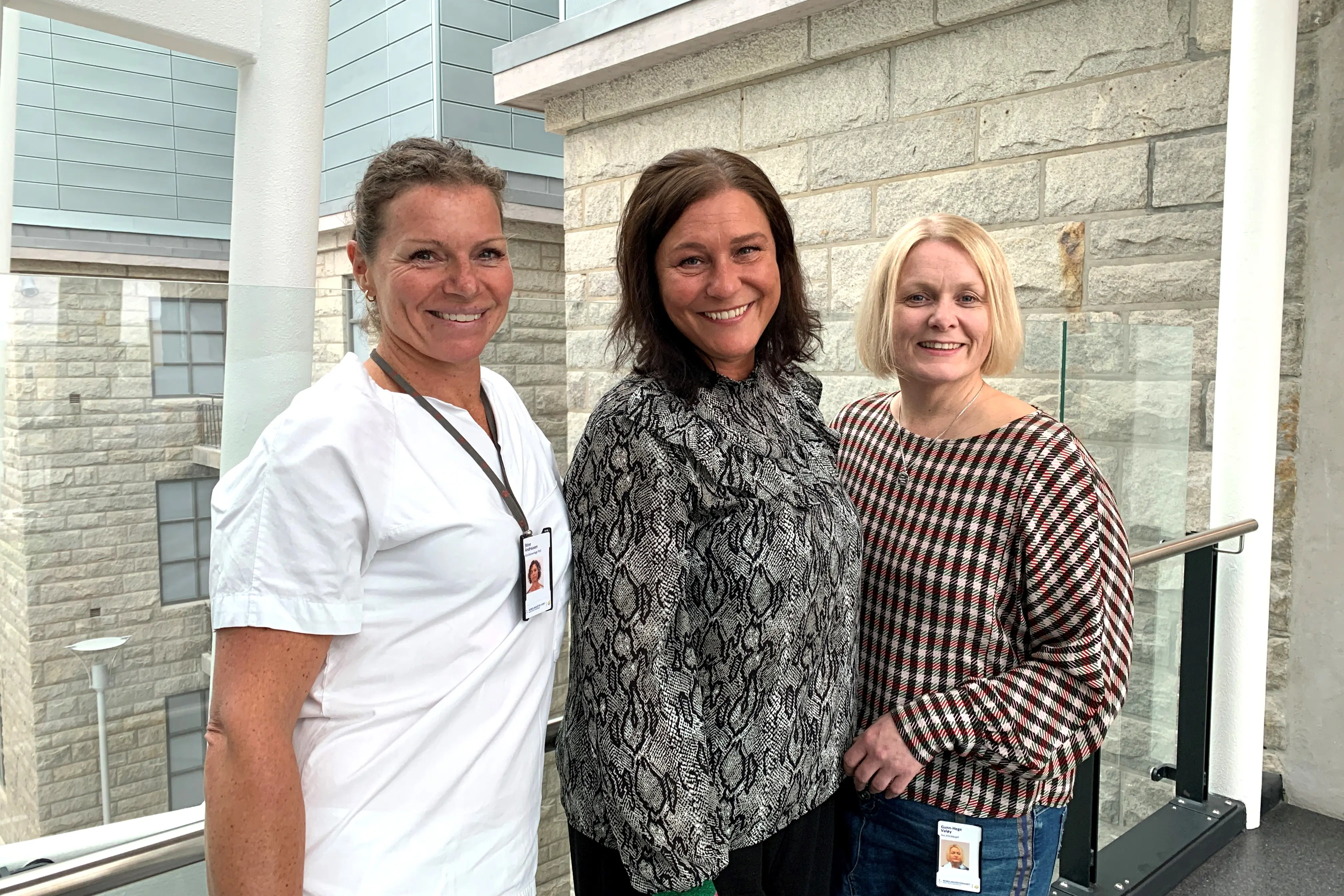 Tre damer oppstilt og smilende mot kamera