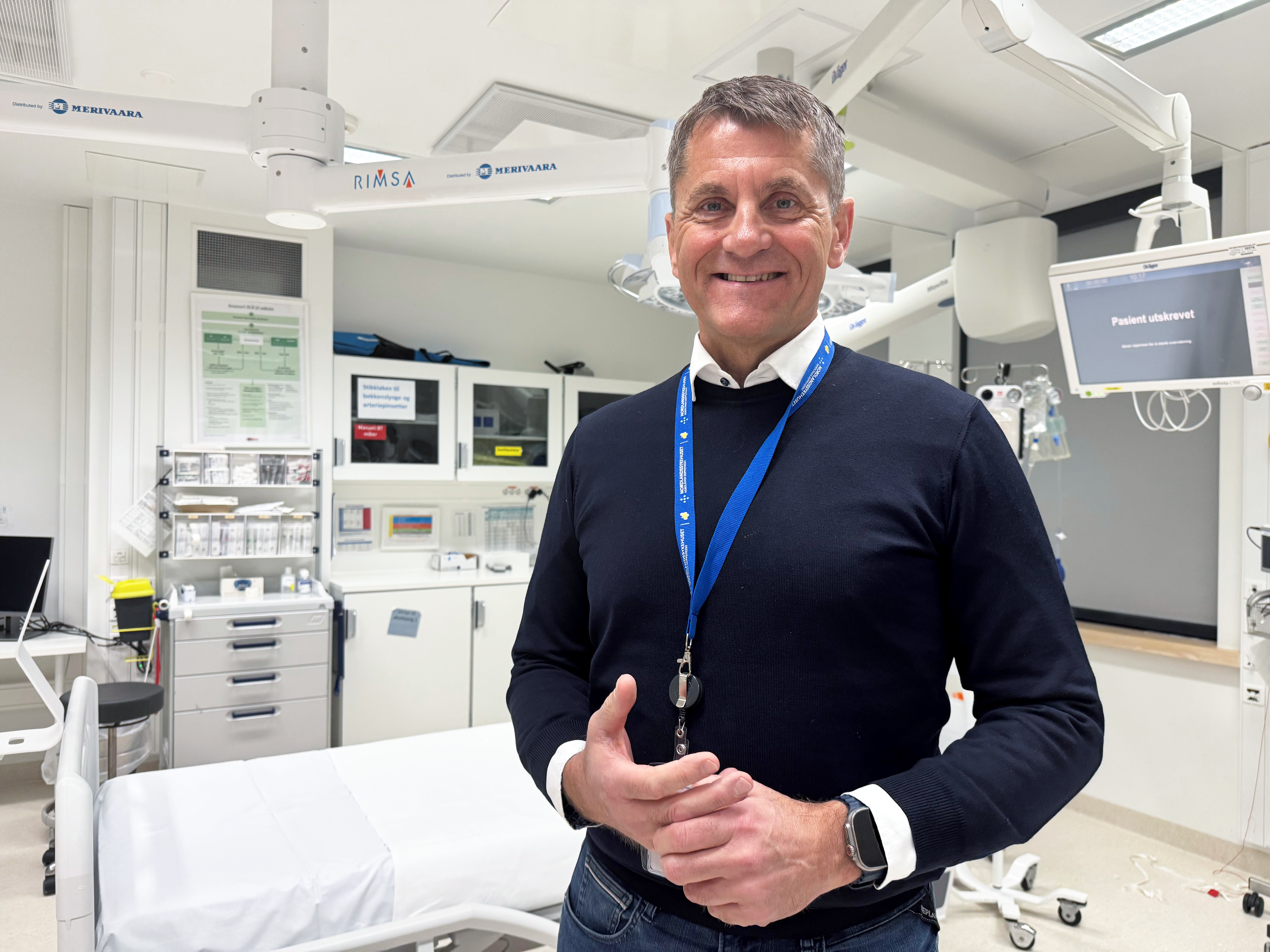 Portrettbilde av mann i svart genser som smiler