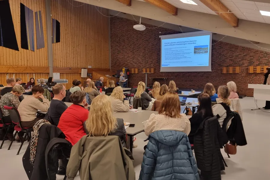 En gruppe mennesker som sitter i et rom og ser på en presentasjon