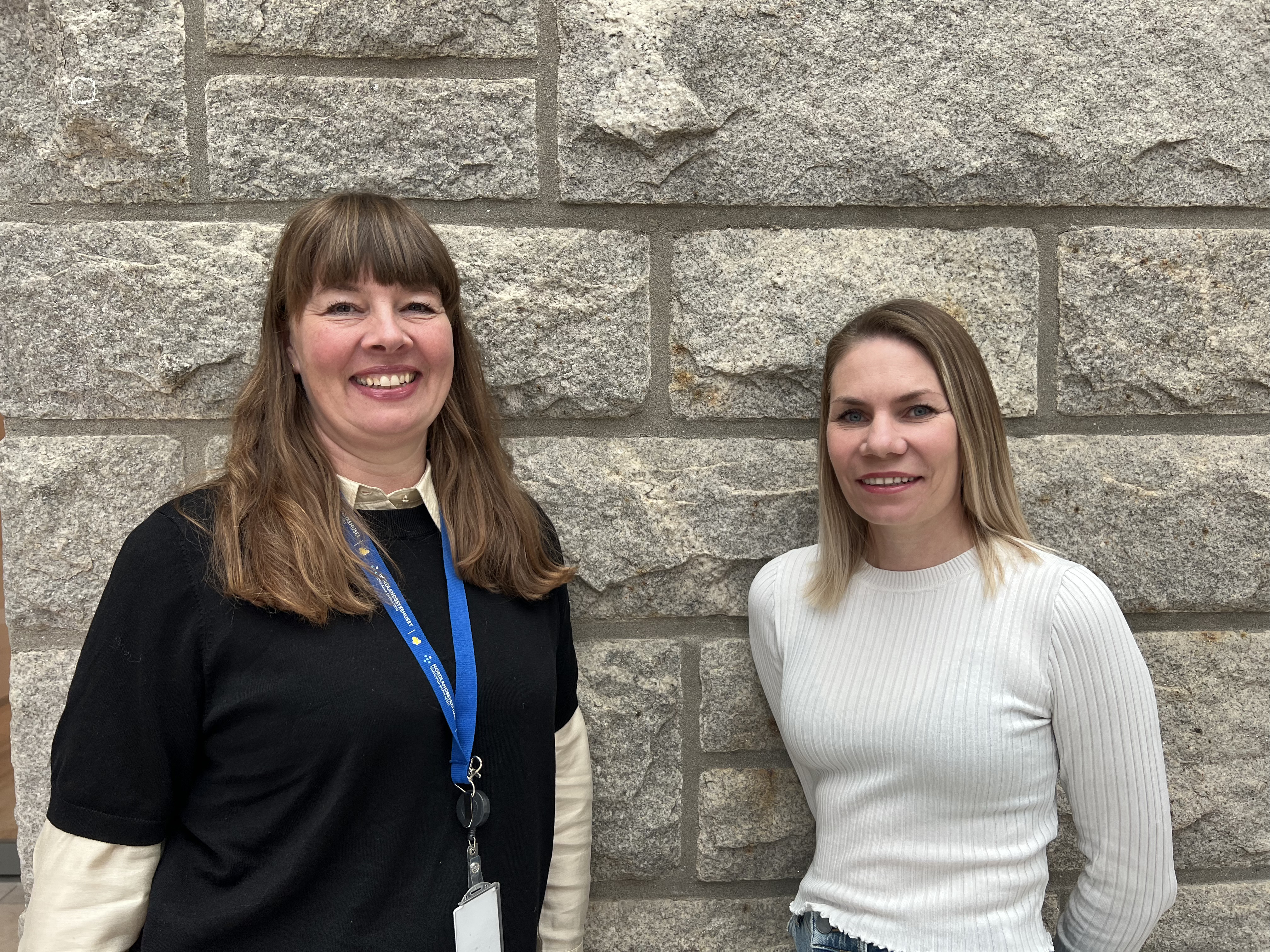 To damer som står og smiler