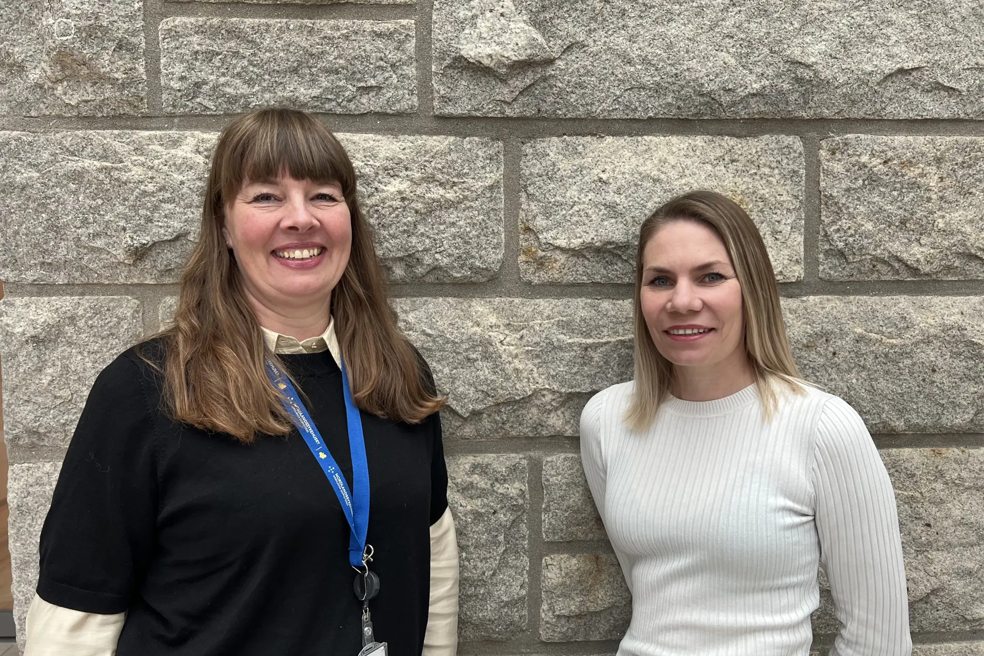 To damer som står og smiler