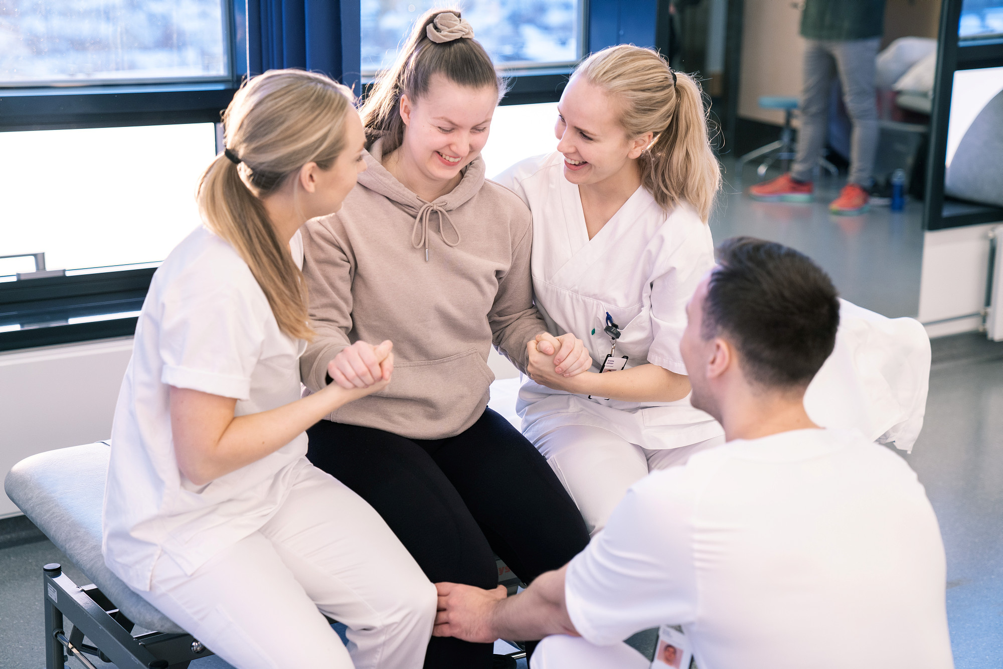 Fysioterapeuter som hjelper ung pasient