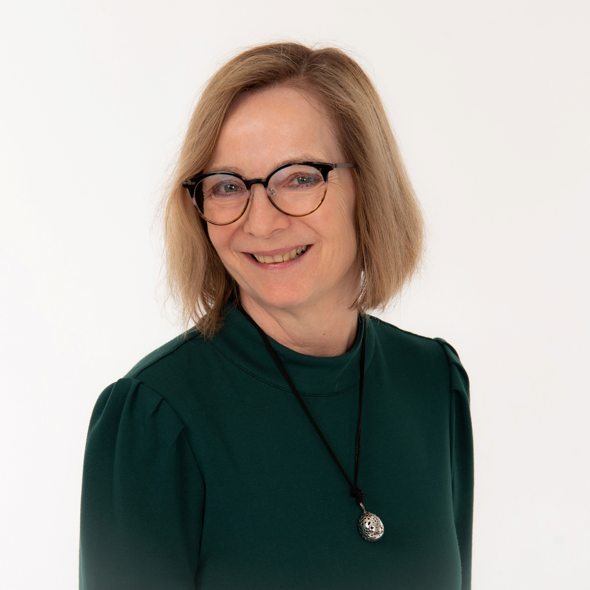 Portrettbilde av dame med briller som smiler