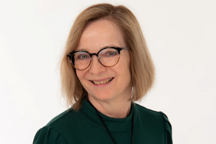 Portrettbilde av dame med briller som smiler