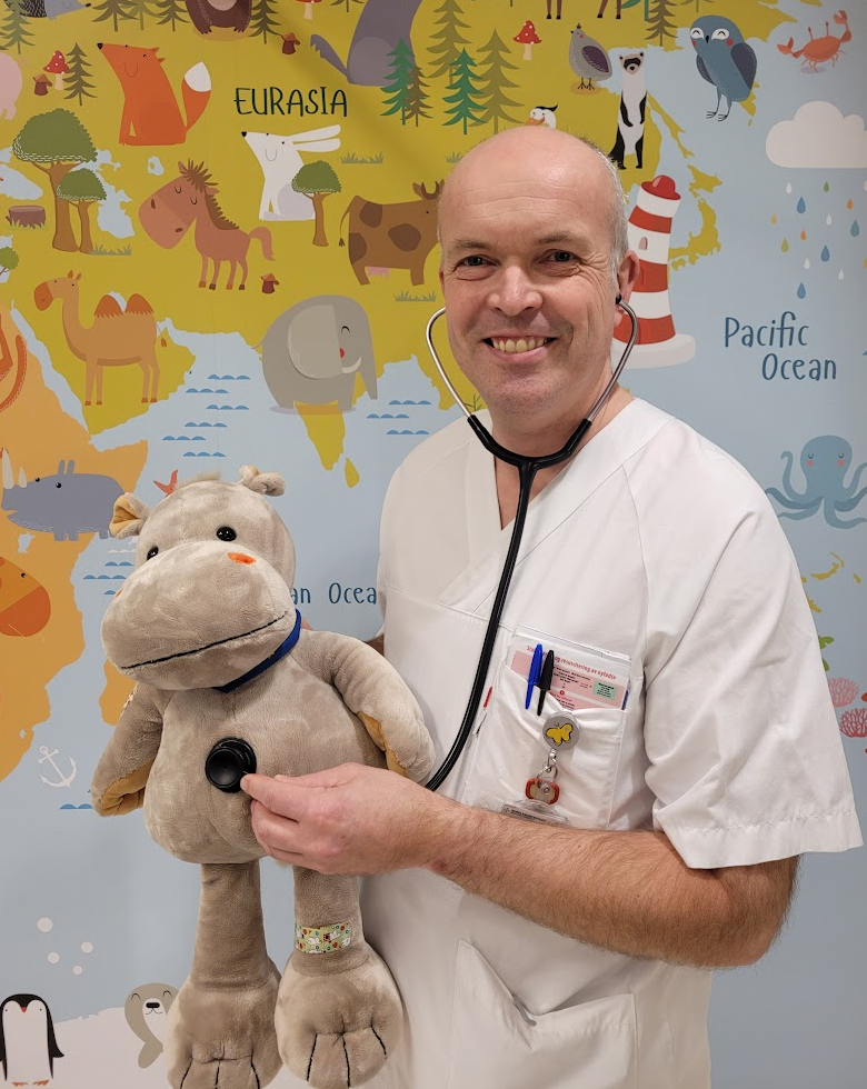 Lege med stetoskop holder en bamse