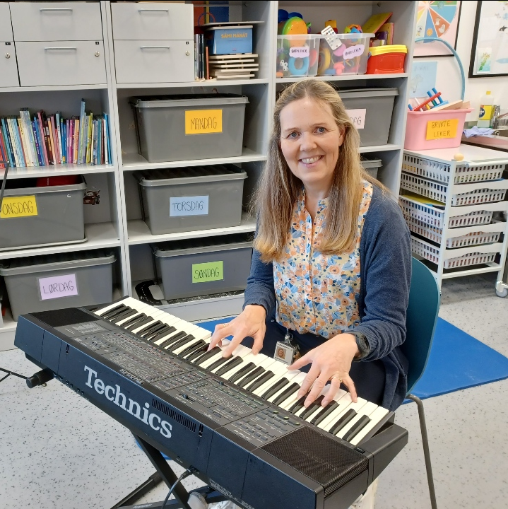 En kvinne som sitter ved et piano