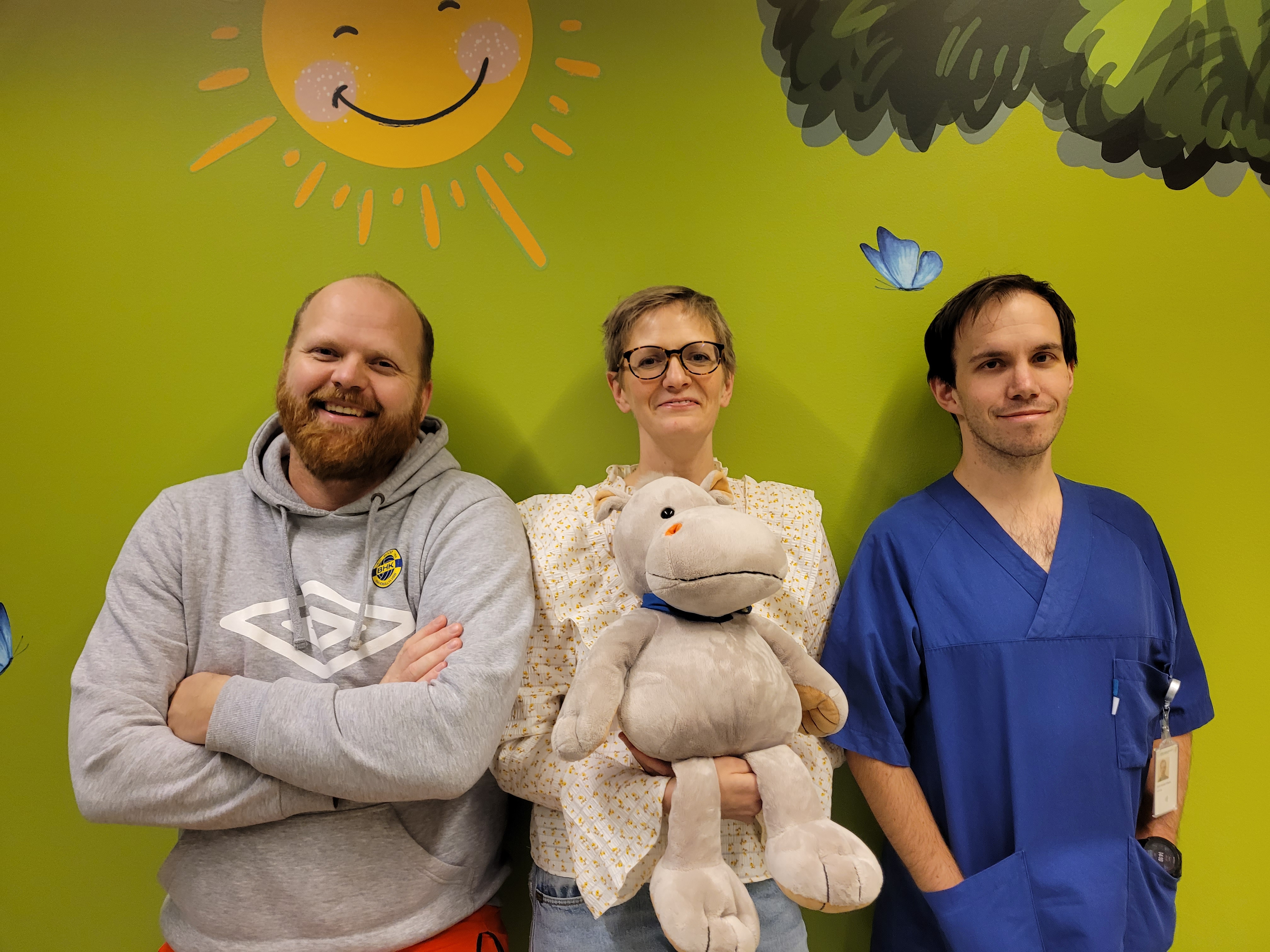 En gruppe menn som poserer med et kosedyr