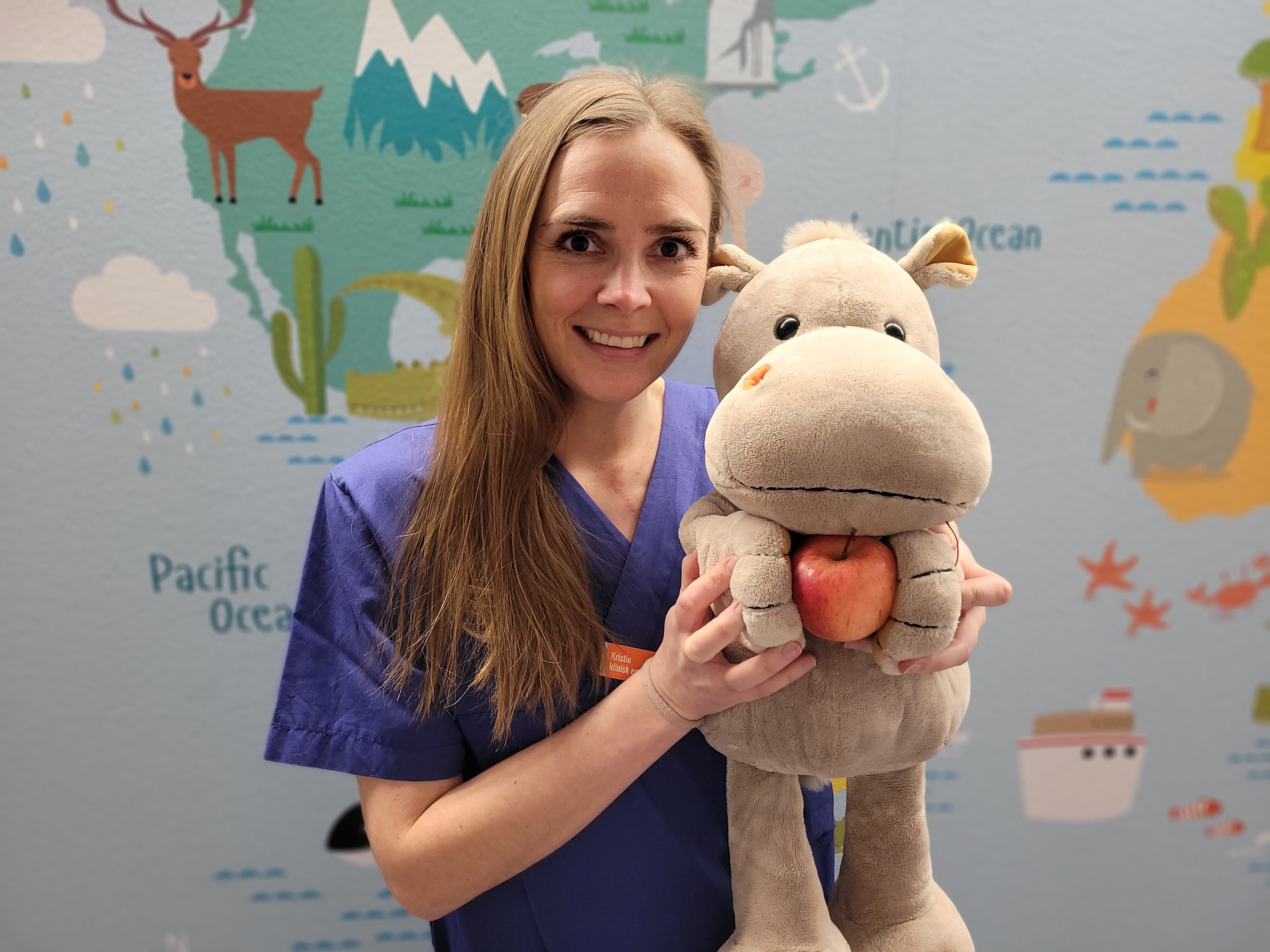 Dame med langt hår som holder en bamse