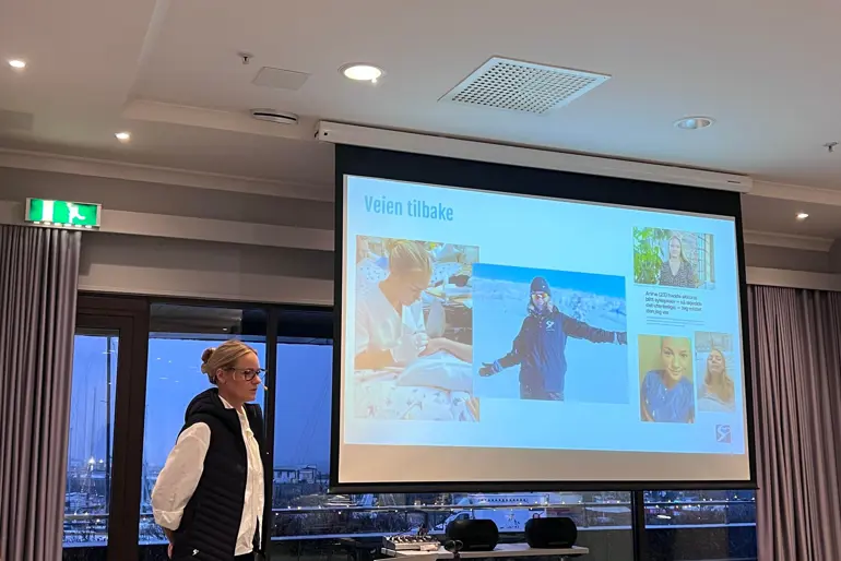 En person som står foran en stor skjerm