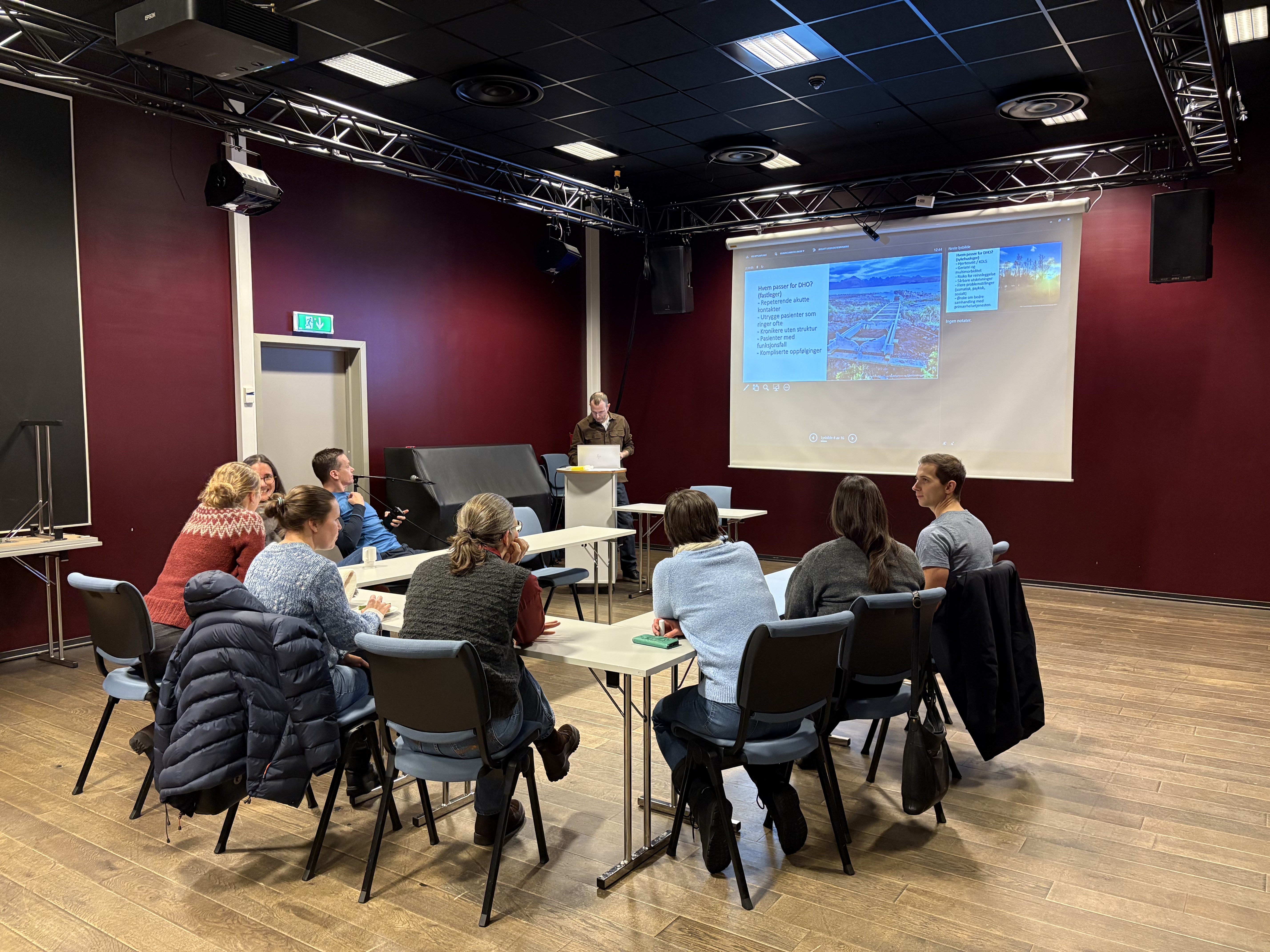 Gruppe mennesker som sitter samlet og ser på presentasjon