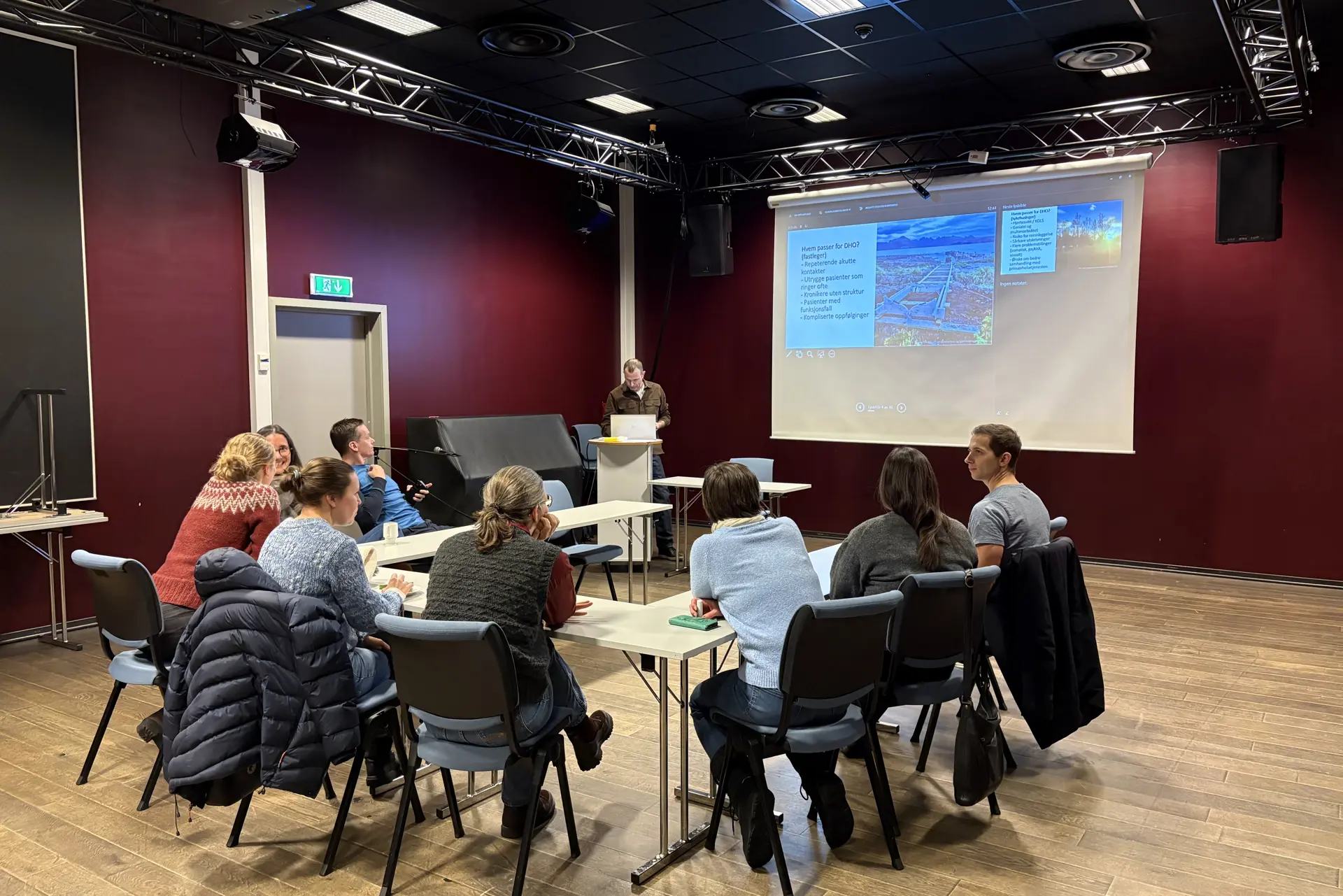 Gruppe mennesker som sitter samlet og ser på presentasjon