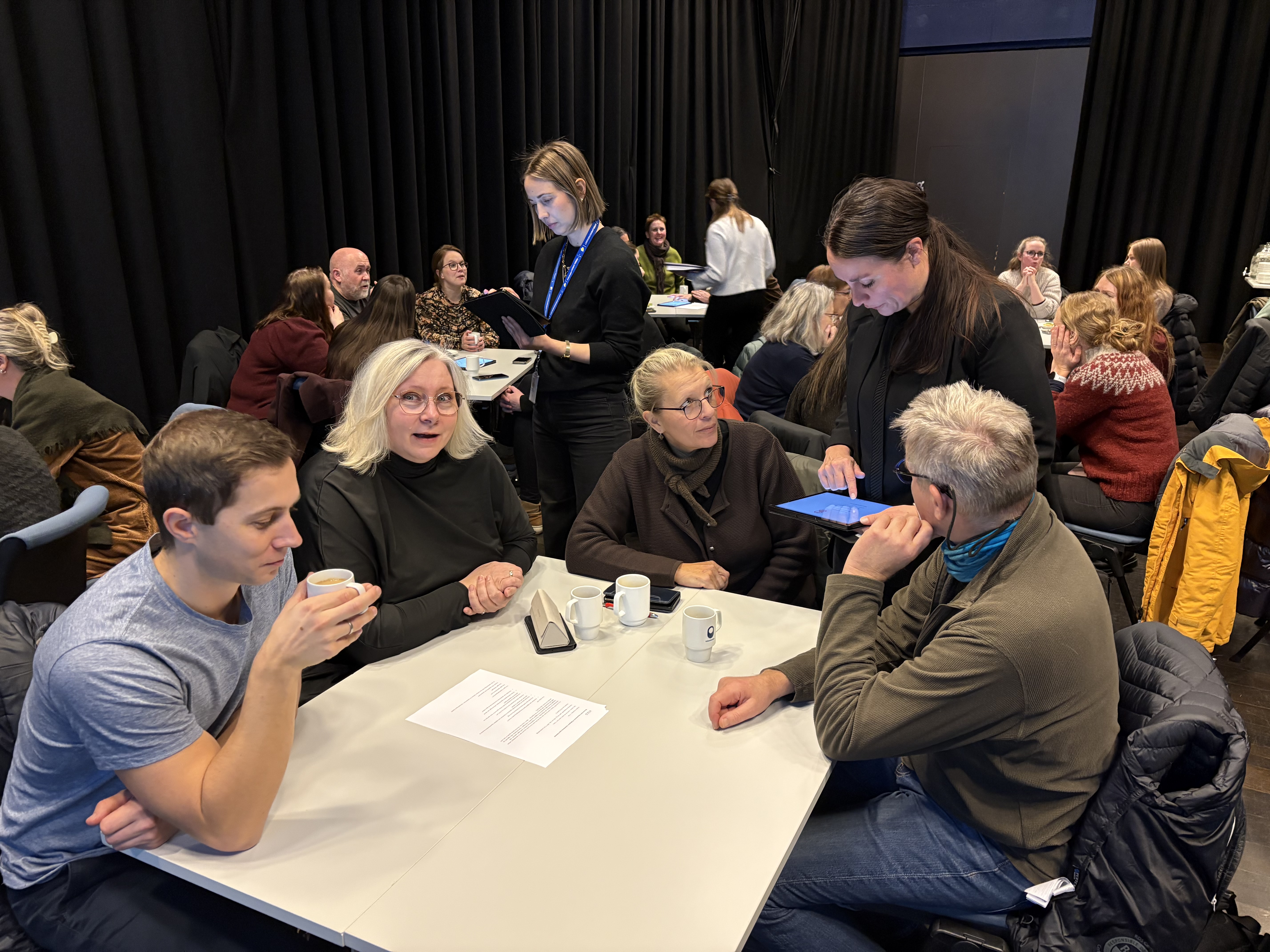 Gruppe mennesker som sitter samlet rundt et bord