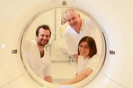 Tre personer som ser igjennom et rør